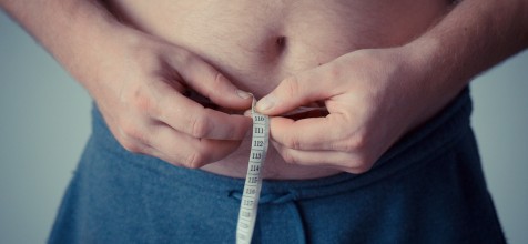 Bauch eines Mannes mit Maßband
