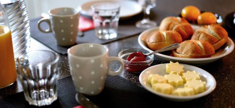 Frühstückstisch mit Brötchen, Butter und Getränken